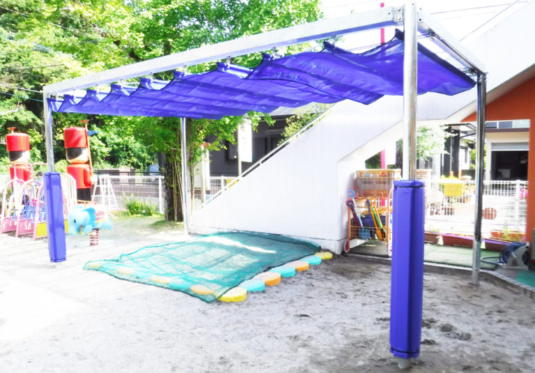 ロールマット使用例：幼稚園の園庭に設置されたテントのポールへ装着
