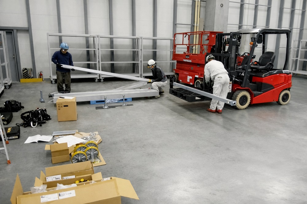組立・設置工事の様子①：梱包されている状態のクレーン部材を開梱し組立